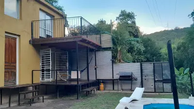 a house with a balcony and a swimming pool at El Rinconcito de la Selva in La Calera