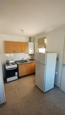 a kitchen with a white refrigerator and a stove at El Roble, casa de sierra in Estancia Vieja