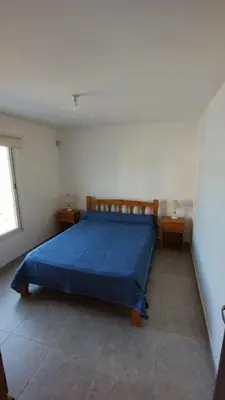 a bedroom with a blue bed with two night stands at El Roble, casa de sierra in Estancia Vieja