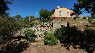 a house on a hill with a stone wall at El Roble, casa de sierra in Estancia Vieja