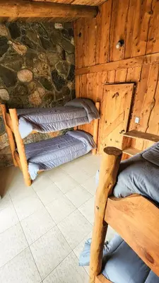 a room with two bunk beds in a log cabin at Ayllupelli in Villa Berna