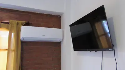 a flat screen tv hanging on a wall in a room at Suites Del Centro in Santa Rosa de Calamuchita