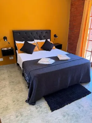 a bedroom with a large bed with two towels on it at Suites Del Centro in Santa Rosa de Calamuchita