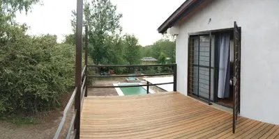 a balcony with a wooden deck next to a house at 