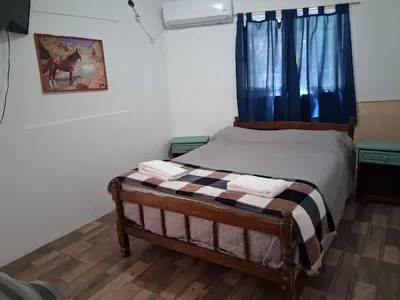 a bedroom with a bed with blue curtains at Don Carlos, para 2 personas con aire in Villa Cura Brochero