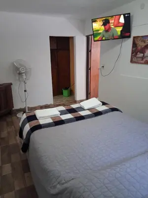 a bedroom with a bed with a tv on the wall at Don Carlos, para 2 personas con aire in Villa Cura Brochero