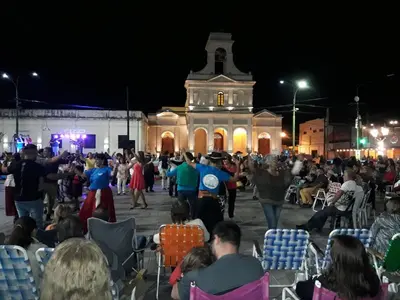 a crowd of people sitting in chairs in front of a building at Don Carlos, para 2 personas con aire in Villa Cura Brochero