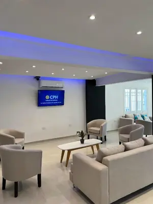a waiting room with couches and a tv on a wall at Hotel Storge by CPH in Villa Carlos Paz