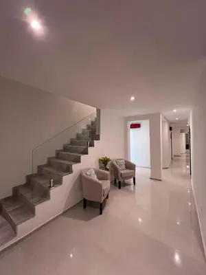 a staircase in a house with two chairs at Hotel Storge by CPH in Villa Carlos Paz