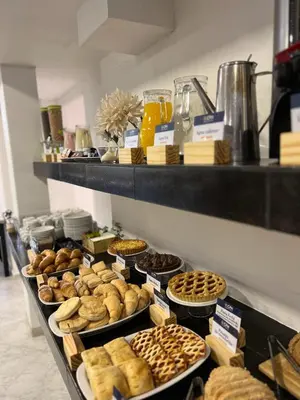 a display case with different types of pastries and pies at Hotel Storge by CPH in Villa Carlos Paz