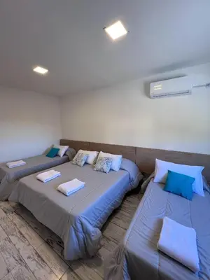 two beds in a room with blue pillows at Hotel Storge by CPH in Villa Carlos Paz