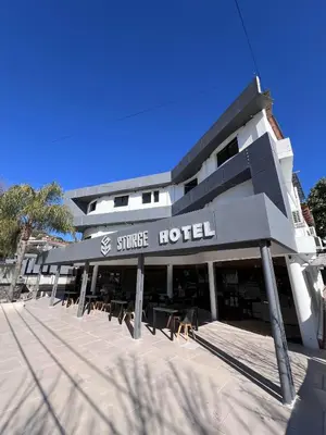 a building with a street hotel with chairs in front at Hotel Storge by CPH in Villa Carlos Paz