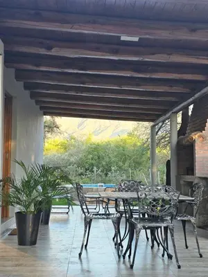 a patio with a table and chairs on a porch at Raíces serranas in Villa de Las Rosas