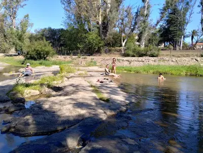 a group of people swimming in a river at baja in Villa Carlos Paz