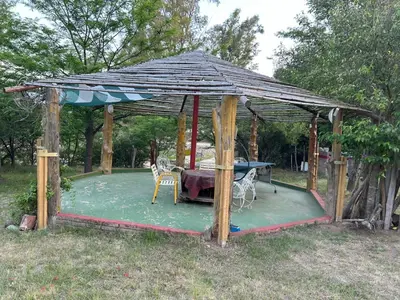 a wooden gazebo with a table and chairs at baja in Villa Carlos Paz