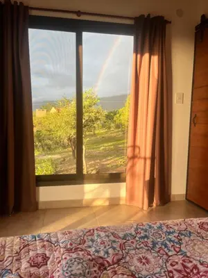 a bedroom with a bed and a window with a rainbow at Flor Silvestre in Carpintería