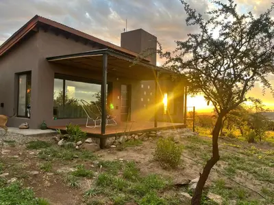 a small house with a sunset in the background at Flor Silvestre in Carpintería