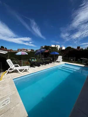 a large blue swimming pool with chairs and umbrellas at La Merlina in Merlo