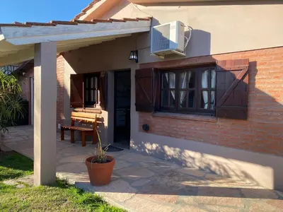 a house with a patio with a window and a piano at La Merlina in Merlo