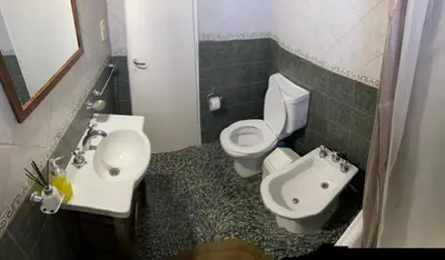 a bathroom with a white toilet and a sink at La Merlina in Merlo