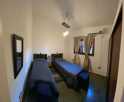 a bedroom with a blue bed and a window at La Merlina in Merlo