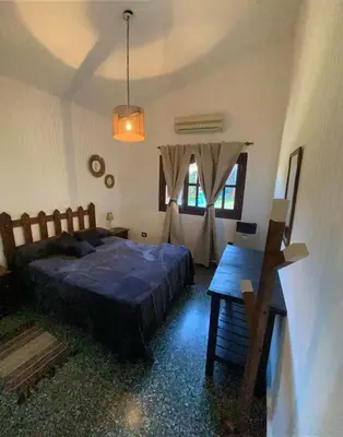 a bedroom with a bed and a table in it at La Merlina in Merlo