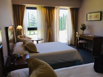 a hotel room with two beds and a desk at San Miguel Plaza Hotel All Inclusive in Villa San Miguel