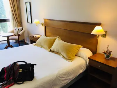 a hotel room with a bed with a purse on it at San Miguel Plaza Hotel All Inclusive in Villa San Miguel