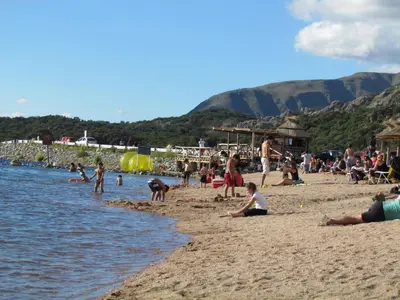 a group of people on a beach near the water at Cabañas de Montaña San Miguel in Cortaderas