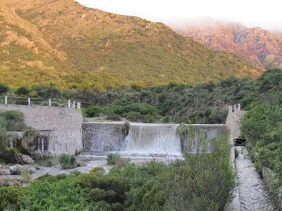 a waterfall in the middle of a mountain at Cabañas de Montaña San Miguel in Cortaderas