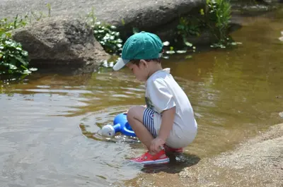 a young boy playing with a toy in the water at Hosteria Sans Souci in Tanti