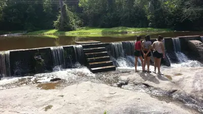 a group of people standing in front of a waterfall at Hosteria Sans Souci in Tanti