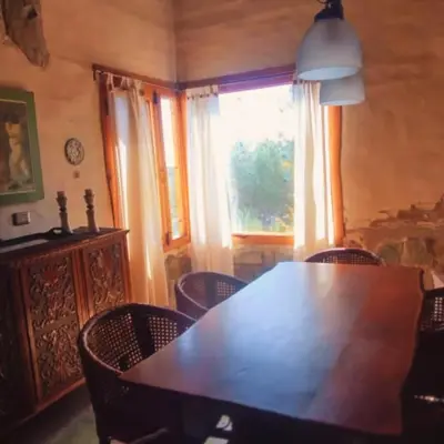 a dining room with a table and chairs and a window at La Calandria in Los Hornillos