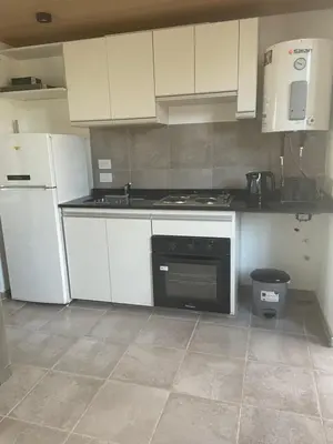 a kitchen with white cabinets and a stove top oven at DEPARTAMENTO Guemes a mts de Nva Córdoba y centro Terraza y pileta! in Cordoba