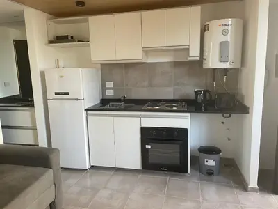 a kitchen with white cabinets and a stove top oven at DEPARTAMENTO Guemes a mts de Nva Córdoba y centro Terraza y pileta! in Cordoba