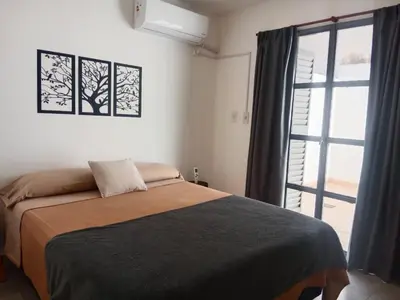 a bedroom with a bed and a large window at Hermoso departamento a metros del centro de la ciudad !! in Cordoba