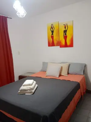 two beds in a room with two paintings on the wall at Hermoso departamento a metros del centro de la ciudad !! in Cordoba