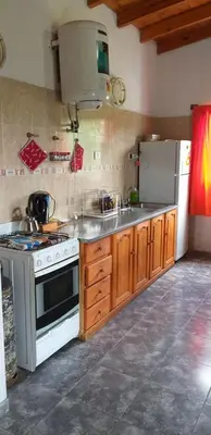a kitchen with a white stove and a refrigerator at Estancia Charo in Villa Carlos Paz