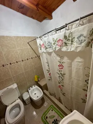 a bathroom with a toilet and a shower curtain at Estancia Charo in Villa Carlos Paz