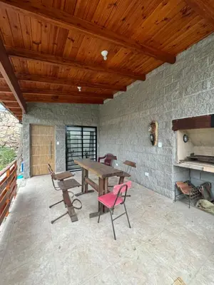 a patio with a wooden ceiling and a table and chairs at Estancia Charo in Villa Carlos Paz