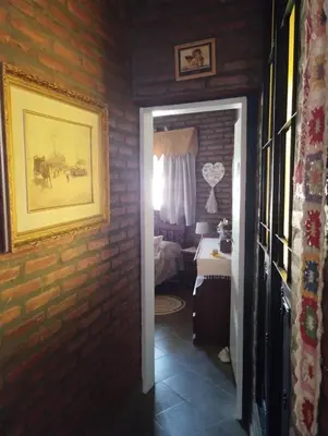 a room with a brick wall and a door to a bedroom at Gracias Viejo in Merlo