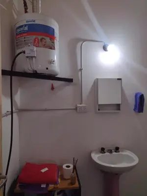 a bathroom with a sink and a light on the wall at El CAMPITO in La Ramada