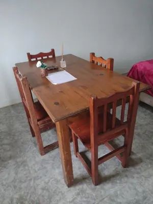 a wooden table with two chairs and a table with papers on it at El CAMPITO in La Ramada