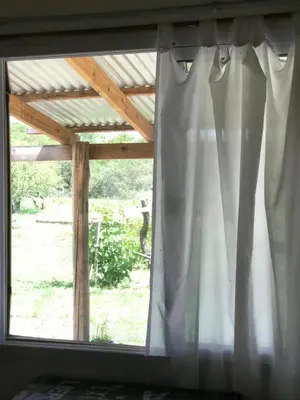 a window with a white curtain in a room at El CAMPITO in La Ramada