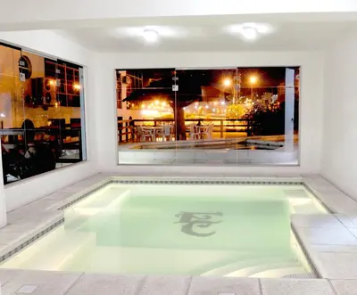 a swimming pool in a house with a window at Hotel El Condado in Villa Carlos Paz