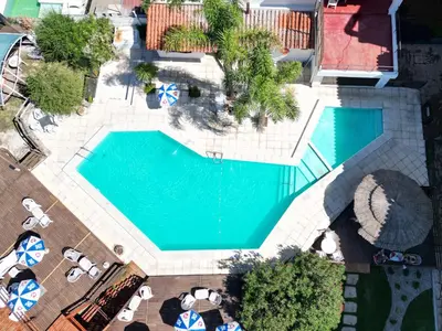 an overhead view of a swimming pool with chairs and umbrellas at Hotel El Condado in Villa Carlos Paz
