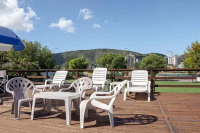 a group of white chairs and tables on a deck at Hotel El Condado in Villa Carlos Paz