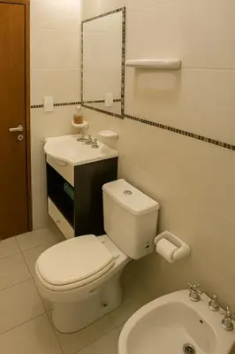 a white bathroom with a toilet and a sink at Departamento 