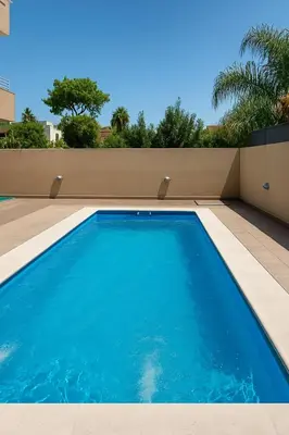 a large blue swimming pool on the side of a house at Departamento 