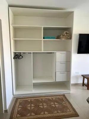 a white closet with white shelves and a tv at Casaabril in Villa Carlos Paz